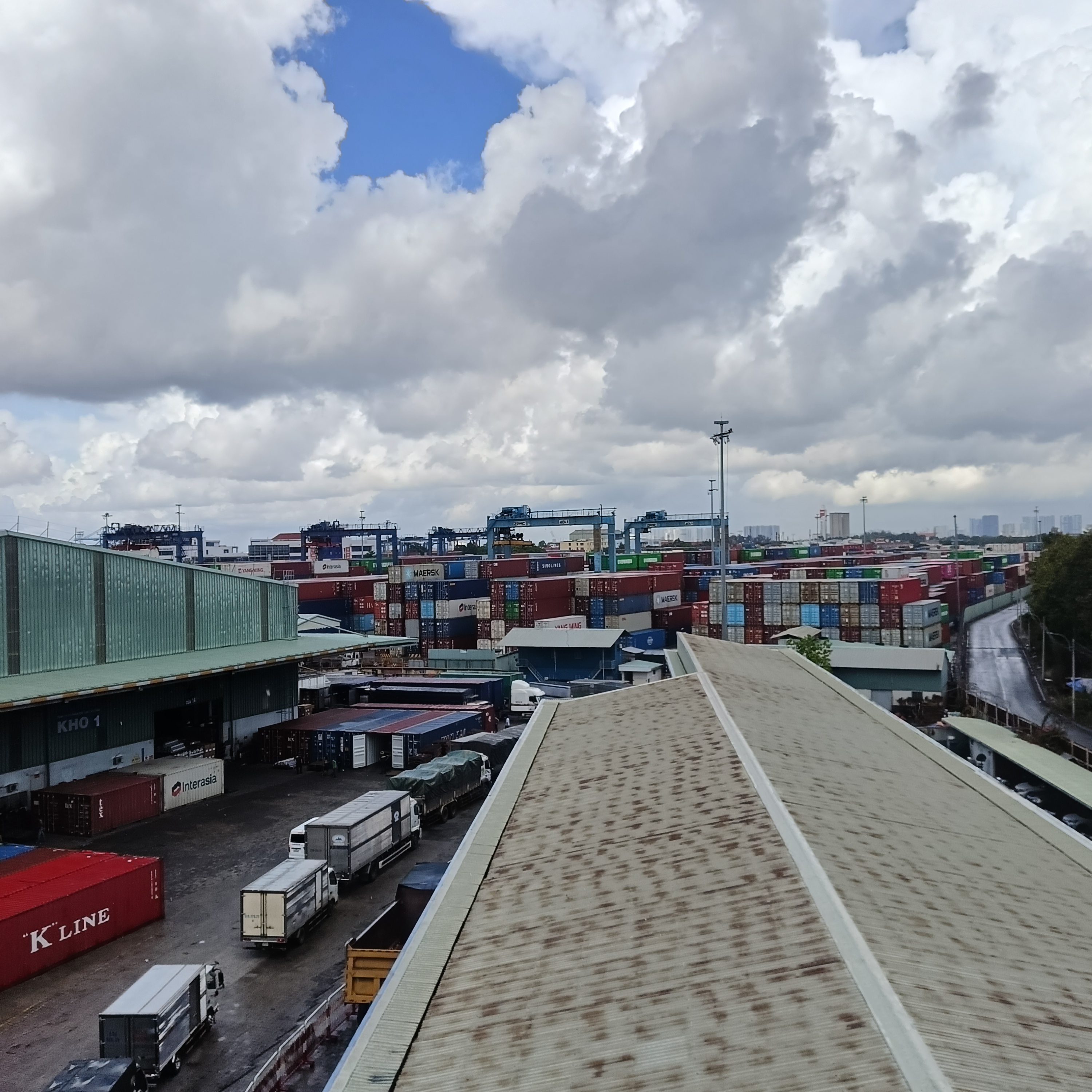 Nhìn từ mái kho: container xếp chồng, cẩu RTG bận rộn.